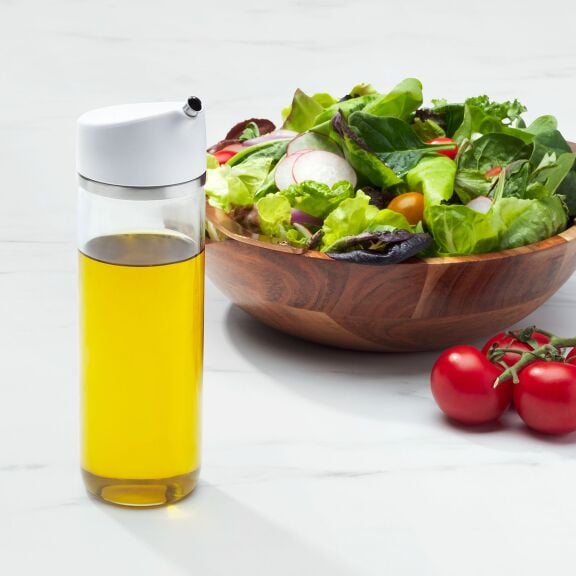 OXO Good Grips 12 oz Precision Pour Glass Dispenser with oil next to salad