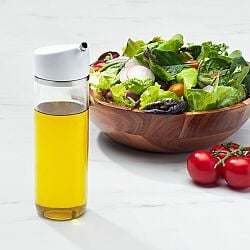 OXO Good Grips 12 oz Precision Pour Glass Dispenser with oil next to salad